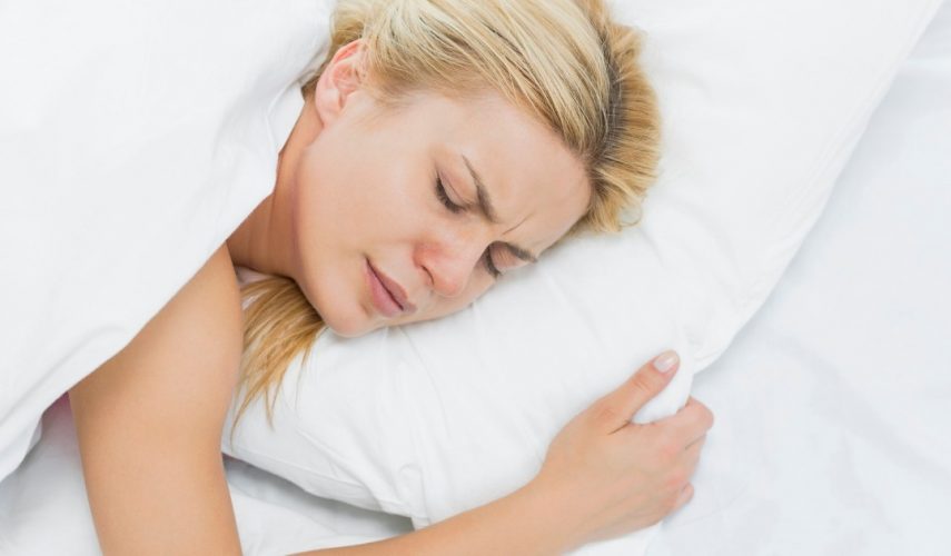 beautiful blonde women lying in bed suffering with fibromyalgia