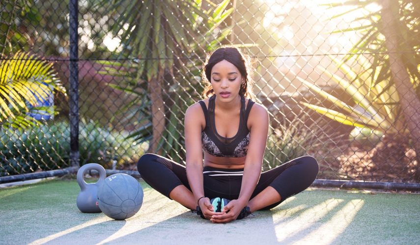 young women stretching on a yoga mat preparing for a fitness workout