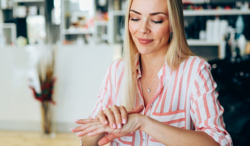Woman applying moisturizing cream on dry hands